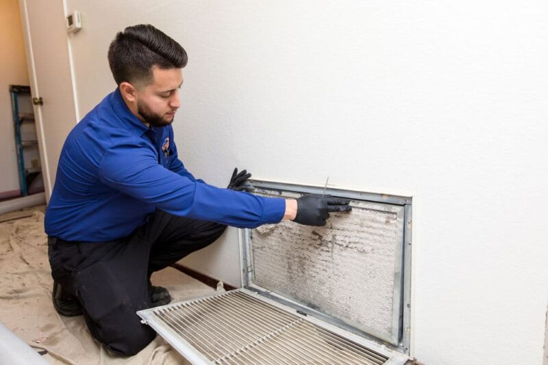 hvac technician switching out dirty air filter in jupiter home