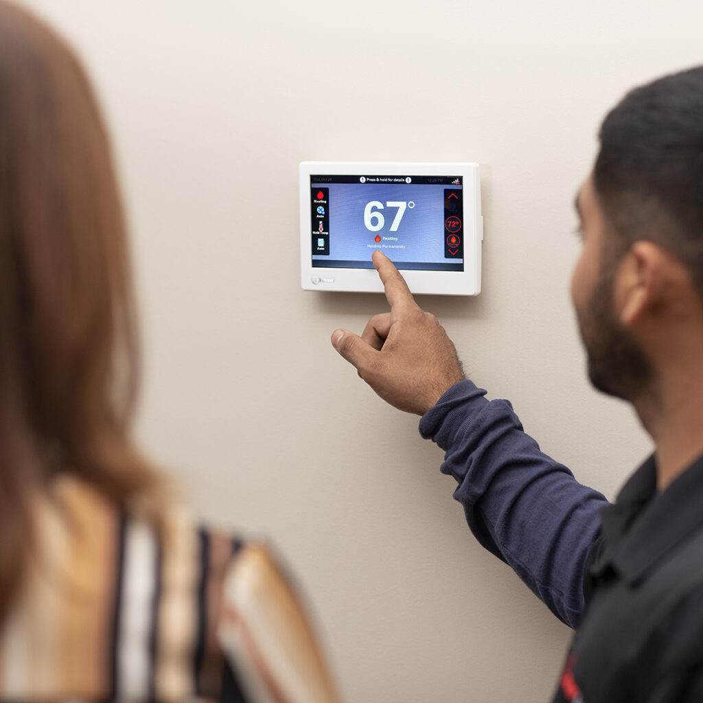 technician showing jupiter homeowner how to operate her newly installed smart thermostat