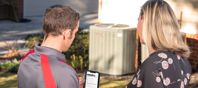 friendly technician showing jupiter homeowner a list of things he found during ac maintenance visit